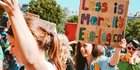 Das Bild zeigt eine Frau, die auf einer Kundgebung ein Plakat mit der Aufschrift "Less ist more -  It's ecological" hochhält.